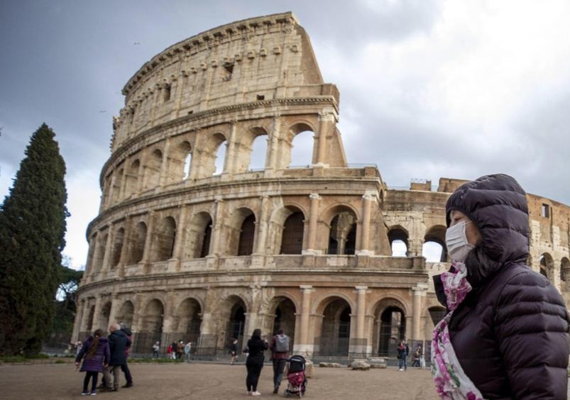 Turista con mascarilla en Coliseo romano